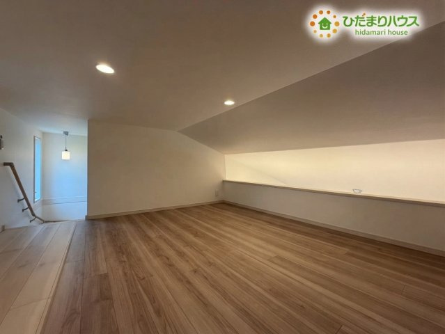 熊谷市野原　中古一戸建ての内装|※AIにて残置物加工
すっきりと広々としたフローリングが広がる、使い勝手の良い小屋裏収納です！天井の傾斜が温かみのある雰囲気を演出し、季節物の家電や大きな荷物もたっぷり収納できます♪