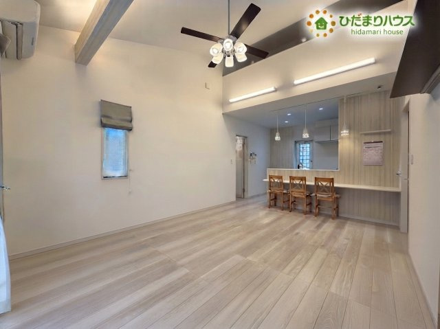 熊谷市野原　中古一戸建ての居間・リビング|※AIにて残置物加工。
勾配天井が開放感を演出する、広々とした明るいリビングです！キッチンカウンターはダイニングスペースとしても利用でき、ご家族との会話も弾みます♪