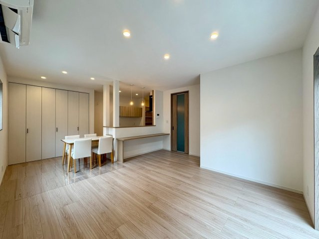 福井町　新築戸建住宅の居間・リビング|温かみのある木目調のフローリングと、ダウンライトの優しい光が心地よい開放的なリビング。
