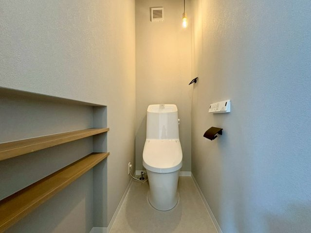 福井町　新築戸建住宅のトイレ|温水洗浄便座付きの清潔感あるトイレ。背面に棚が設置されており、ちょっとした小物置きに便利です。