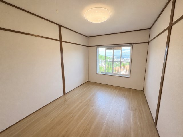 渦ヶ森コーポ壱号館の洋室|窓から開放的な景色が広がります。高台ならではの、心地よい眺望が楽しめる洋室6帖のお部屋です。窓の外には遮るものがなく、遠くの街並みや緑を見渡せます。
（CG加工による家具消しを行っております。）