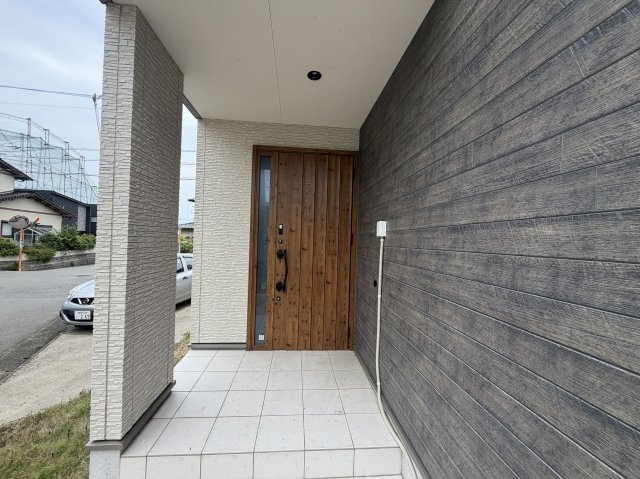 【玄関】 | 福岡市西区野方２丁目 戸建て | 木目調の落ち着いた玄関ドアと外壁が、訪れる人を温かく迎え入れます