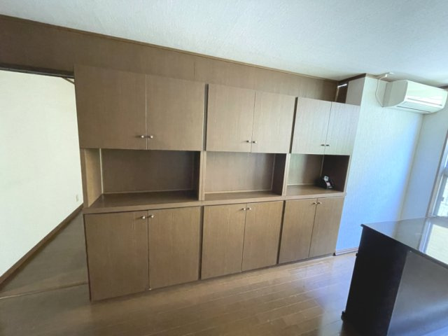 戸坂第一コーポラスのキッチン|ブラウンカラーで落ち着いた雰囲気。キッチングッズやリビング雑貨などがしっかり片付く棚が備わっています