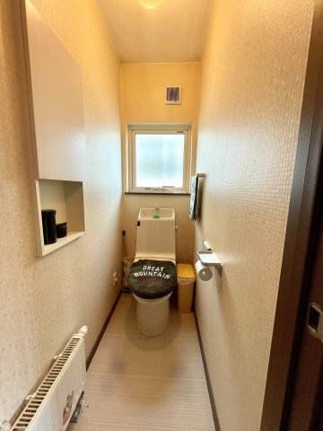 曙12条1丁目　一戸建てのトイレ|玄関横に配置されている窓付きの明るいトイレ、壁面収納スペースがあり小物を収納可能、暖房があり冬も快適に使用可能です。