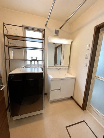 曙12条1丁目　一戸建ての独立洗面台|ドラム式も十分における広さの脱衣場スペース、物干しポールもあり室内干し空間としても利用可能