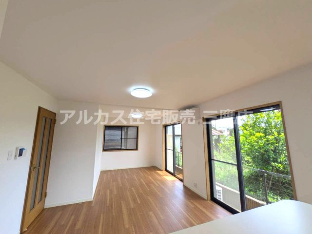 西武新宿線 小平駅 14分 中古戸建 小平市大沼町2丁目の居間・リビング| 複数の窓と木目調の床が印象的な、対面キッチンとつながるLDKです。