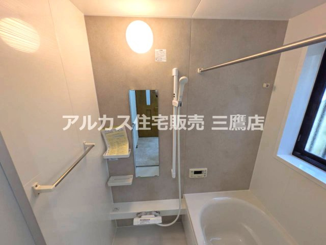 西武新宿線 小平駅 14分 中古戸建 小平市大沼町2丁目の浴室|グレーのアクセント壁と窓が印象的な、物干しバーを備えた浴室です。