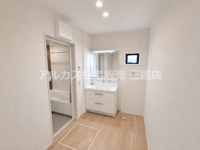 西武多摩川線 新小金井駅 13分 新築戸建 小金井市東町1丁目の洗面所|三面鏡付き洗面化粧台と小窓、洗濯機置場を備えた清潔感ある洗面室です。
