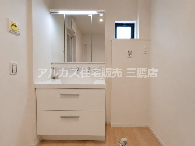 西武多摩川線 新小金井駅 13分 新築戸建 小金井市東町1丁目の独立洗面台|三面鏡付き洗面化粧台と洗濯機置場、小窓を備えた清潔感ある洗面室です。