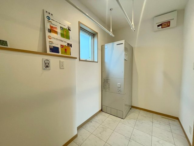西野４条７丁目　新築戸建の脱衣所|室内物干しポールを2本設置した広々とした脱衣室。洗濯機を置いてもゆとりがあり、家事がはかどる空間。タオルや着替えの収納スペースもしっかり確保できます