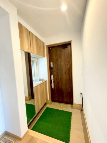 西野４条７丁目　新築戸建の玄関|窓から自然光が差し込む明るい玄関。シューズボックスの他、お出かけ前の身だしなみチェックに便利な全身鏡付きです。