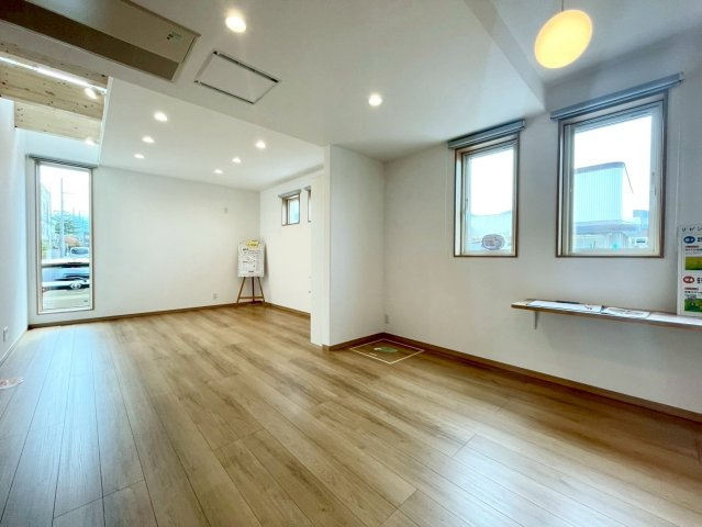 西野４条７丁目　新築戸建の居間・リビング|陽当たりの良い20帖LDK。木目のフローリングや梁、建具、ダウンライトが温もりを演出し、大きな家具を置いてもゆとりのある空間。