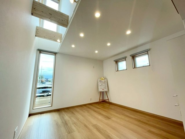 西野４条７丁目　新築戸建の居間・リビング|吹抜けが上下階をゆるやかにつなぎ、家族の距離が近く感じられるリビング。
