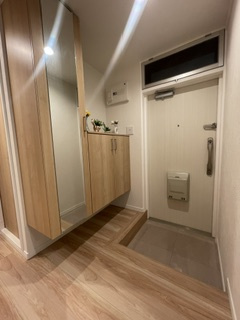 田園調布コーポラスの玄関|温かみのある木目調のデザインでまとめられた明るい玄関。お出かけ前の身だしなみチェックに重宝する、大きな鏡付きのシューズボックスを備えているのが嬉しいポイントです。