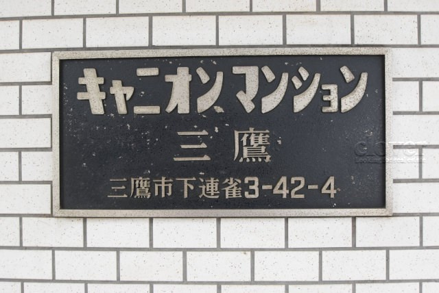 【現況写真】 | キャニオンマンション三鷹 | マンションの入り口に掲げられた、建物名称の表示部分。不動産業界ではこれを「館銘板」と呼びます。～即日のご見学可能～　お問合せはお気軽にどうぞ。
