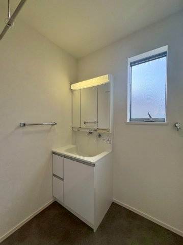 草津市岡本町　中古戸建ての独立洗面台|窓のある洗面室。三面鏡収納付き洗面化粧台で、洗面用品もすっきり整理できます。