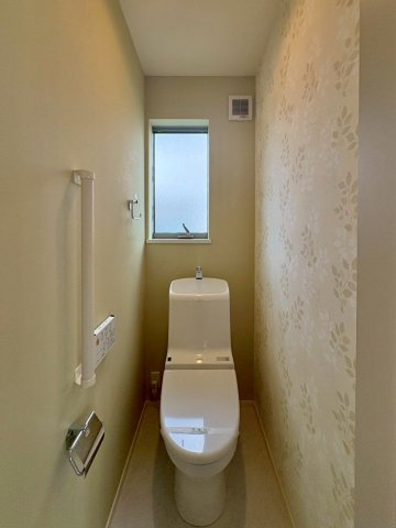 草津市岡本町　中古戸建てのトイレ|窓付きで明るいトイレ。手すりと温水洗浄便座を備え、毎日快適に使えます。
