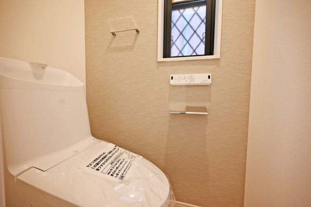 西宮市南甲子園2丁目新築一戸建て｜4LDK＋駐車2台可（制限有）のトイレ|トイレには換気扇と小窓が配置されています。温感便座や温水洗浄、水栓一体などの機能が装備されたウォッシュレットトイレを1階と2階に1か所ずつ配置しています。
