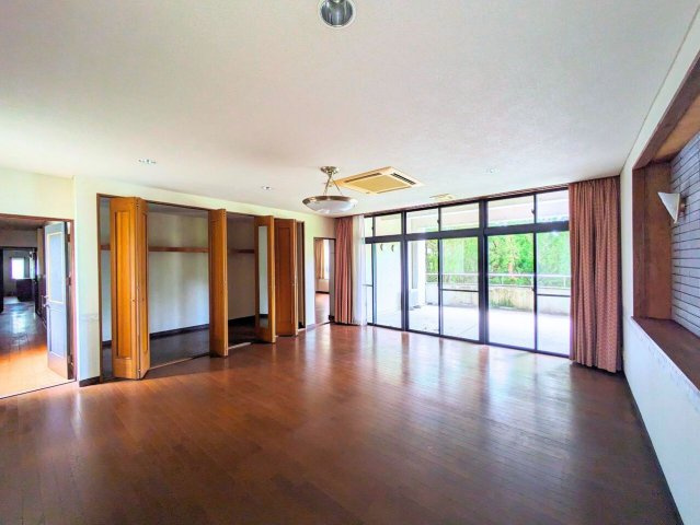 吉藤5丁目3世帯戸建ての洋室|壁一面の大きな窓とバルコニーが開放感を高めます。明るく風通しの良い、気持ちの良いお部屋です。
