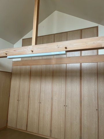 【洋室】 | 設計士が建築したこだわりのウッディーハウス | 東側の洋室　天井髙が高く壁一面の収納は見ものです。　しばらく使用をしないものは一番高いところにある収納に専用のはしごを使って出し入れします。