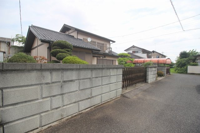 小山市喜沢の外観|塀と植栽に囲まれた、プライバシーに配慮された住まい。敷地内の落ち着いた様子がうかがえます。
