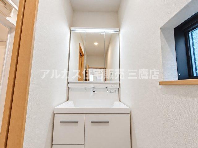 中央線 武蔵小金井駅 10分 新築戸建 小金井市緑町5丁目の独立洗面台|身だしなみを整えやすい三面鏡付きの洗面化粧台。足元のスライド収納や横の小窓など、使いやすさと明るさを両立しています。