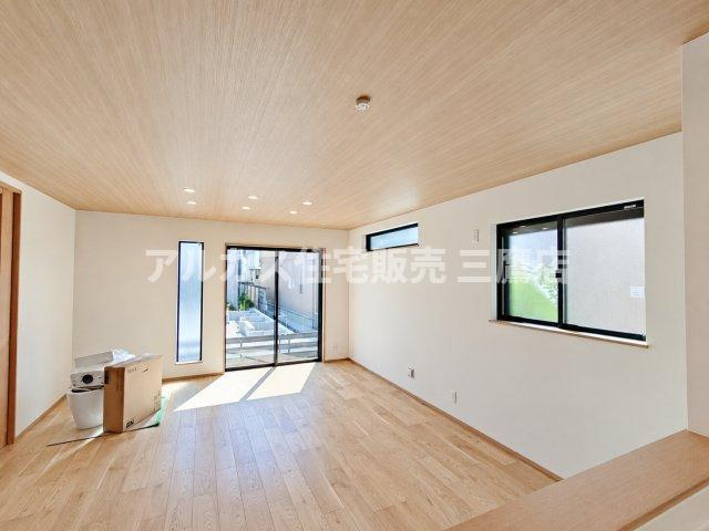 中央線 武蔵小金井駅 10分 新築戸建 小金井市緑町5丁目の居間・リビング|木目調クロスをあしらった天井と温かみのある床材が印象的なリビング空間。複数配された窓から自然光が心地よく差し込みます。