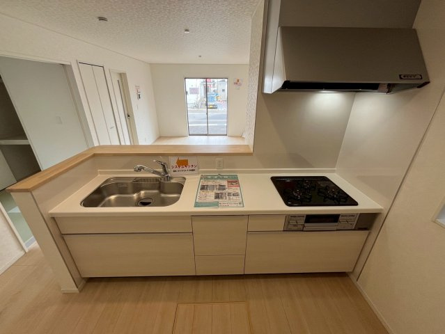 【仲介手数料無料】富士見市水谷東第11―新築分譲住宅―限定１棟―の内観：施工例|（施工例）白を基調としたキッチン。奥には冷蔵庫や棚を置けるゆとりあるスペースを確保し、デザイン性と作業のしやすさを兼ね備えたスタイリッシュな空間です