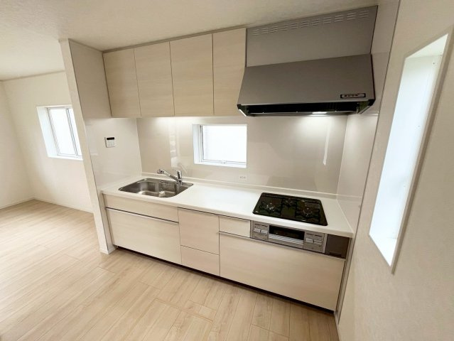 【仲介手数料無料】富士見市東大久保―新築分譲住宅―最終１棟―のキッチン|白を基調としたキッチン。奥には冷蔵庫や棚を置けるゆとりあるスペースを確保し、デザイン性と作業のしやすさを兼ね備えたスタイリッシュな空間です