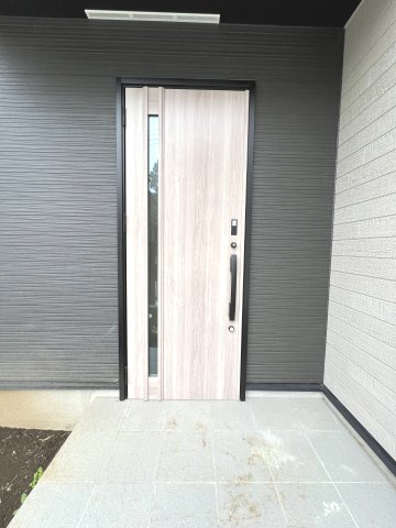 青梅市長淵1丁目　新築戸建全10棟の玄関|やさしい木目調の玄関ドアが、モダンな外観に温もりをプラス♪スリット窓から光を取り込む、明るくスタイリッシュなエントランスです。
