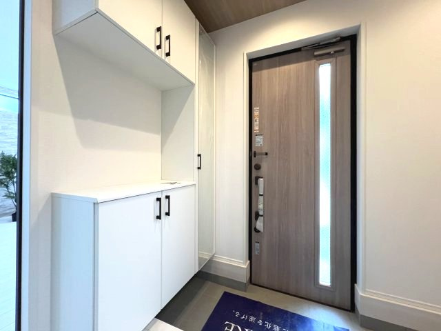 青梅市長淵1丁目　新築戸建全10棟の玄関|天井までの高さがあるタップリ玄関収納、姿見付きなのも便利