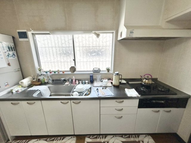 中古戸建　川西市大和西5丁目のキッチン|白を基調とした清潔感のある広いキッチンスペース。リビングと食事が分かれ、生活感の目隠しや省エネが叶います。