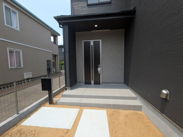 つくばみらい市伊奈東41番　新築戸建て　A号棟の玄関|お洒落な玄関ドアと洗練された外壁デザイン。家の顔にふさわしい上質な佇まいで、ご家族やお客様を迎えます。