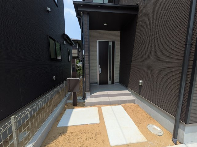 つくばみらい市伊奈東41番　新築戸建て　B号棟の玄関|お洒落な玄関ドアと洗練された外壁デザイン。家の顔にふさわしい上質な佇まいで、ご家族やお客様を迎えます。