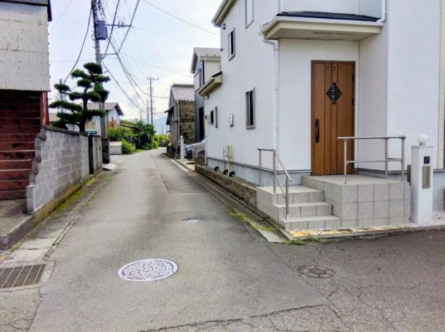 売中古戸建　三島市安久の前面道路含む現地写真|車の通り抜けが少ない閑静な住宅街です。手すり付きの階段が設置された、優しさと安心感のある玄関アプロ－チです。