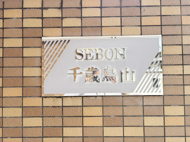 【現況写真】 | セボン千歳烏山 | エントランスに掲げられた、マンション名を示す館銘板。さほど激しく主張はしませんが、しっかりと掲示されています。～即日のご見学可能～　お問合せはお気軽にどうぞ。