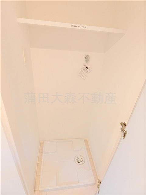 パティーナ蒲田Duoの設備|棚と扉付きの室内洗濯機置き場
