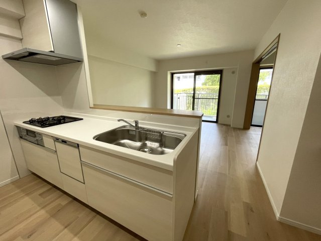ラ・ヴェール芦屋Ⅲ6号棟のキッチン|キッチンは対面式。外には緑があって癒されます。