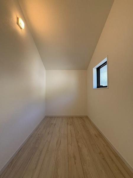 横浜市鶴見区梶山１丁目の新築一戸建の収納|シンプルな内装で清潔感のある収納スペースです。天井の照明がしっかり明るさを確保しています。窓があるため換気や採光も可能です。床は木目調で落ち着いた雰囲気が感じられます。
