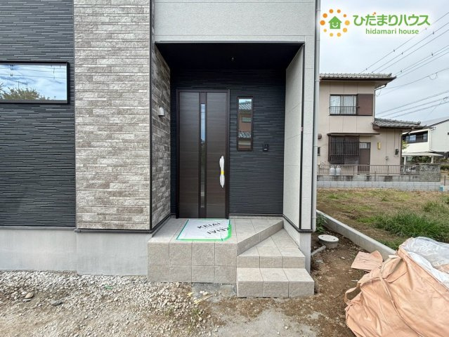 熊谷市別府　1期　新築一戸建て　リガーレ　02の玄関|スタイリッシュな玄関ドアがすっきりとした印象を与えるアプローチです！屋根付きのポーチがあるため雨の日の傘の開閉も濡れずに行えます♪段差が少なく小さなお子様も安心して出入りできる優しい設計です！