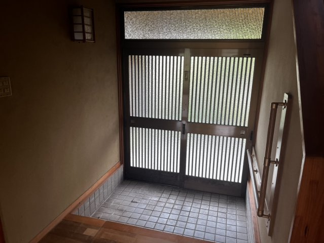 天満台東三丁目の玄関|格子ガラスの引き戸から柔らかな光が入る玄関。手すり付きで昇り降りも安心です