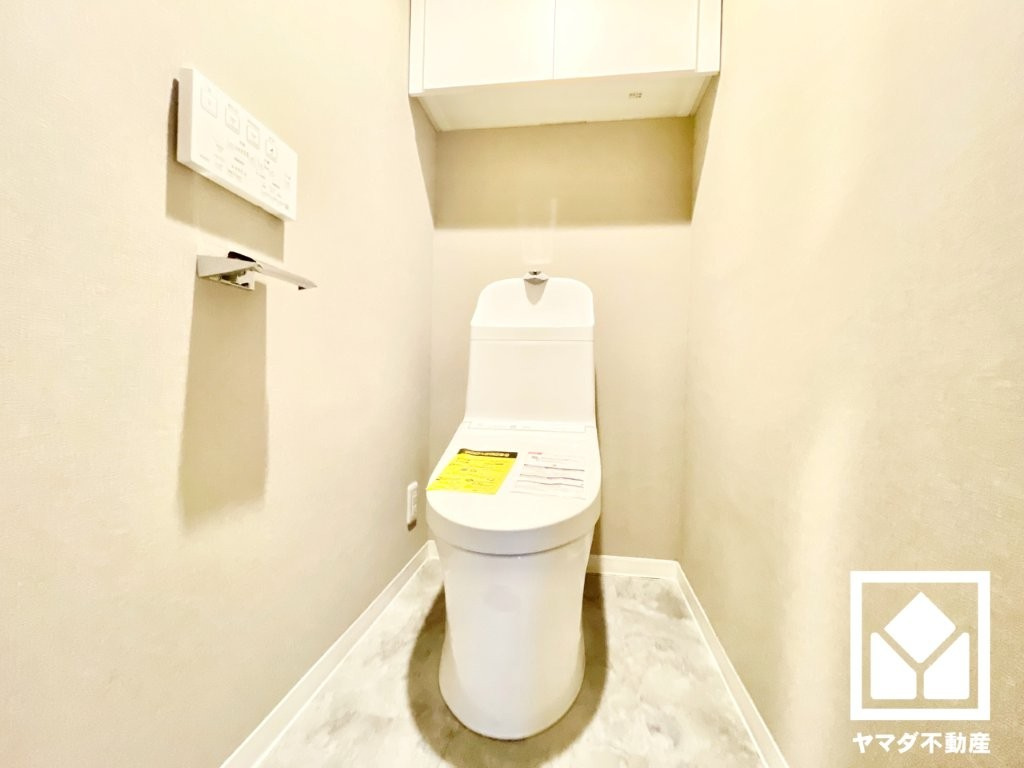 ジークレフ第二武庫川のトイレ|明るく清潔感溢れるトイレです。温水洗浄便座付きで、季節を問わずいつでも温かい便座をお使いいただけます。トイレットペーパーのストックや消耗品置き場などとしてお使いいただける吊戸棚を備えています。