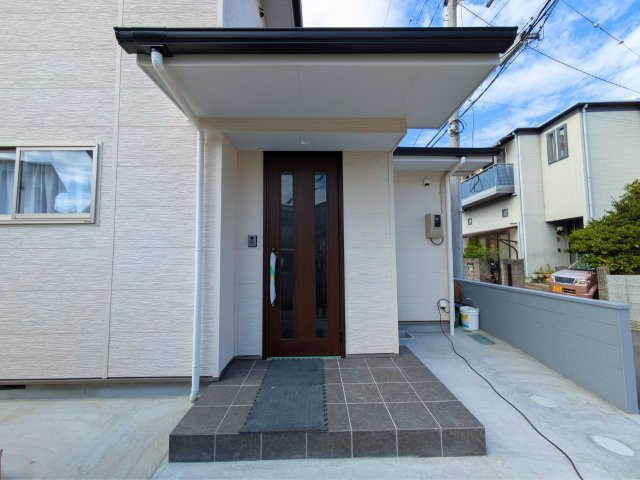 土居町戸建ての玄関|ひさし付きのポーチ玄関。雨天時の出入りや荷物の積み降ろしに配慮された設計。