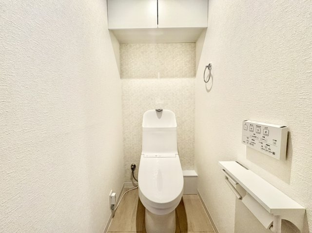 ワコーレ御影郡家のトイレ|トイレ上部にはトイレットペーパーや掃除用品をすっきり目隠し収納できる扉付きの吊戸棚を設置。余計なものを床に置かずに済むため、空間を広く使えてお掃除も簡単、常に清潔な状態をキープできます