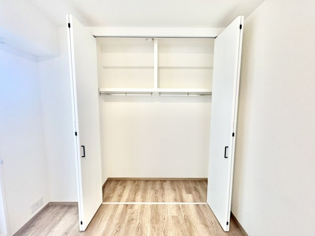 ワコーレ御影郡家の収納|洋服をたっぷり掛けられるハンガーパイプ付きの大型クローゼット。上部には枕棚があり、シーズンオフの衣類や旅行カバンもすっきり収まります。2人分の荷物もきれいに整理できて主寝室に最適です。