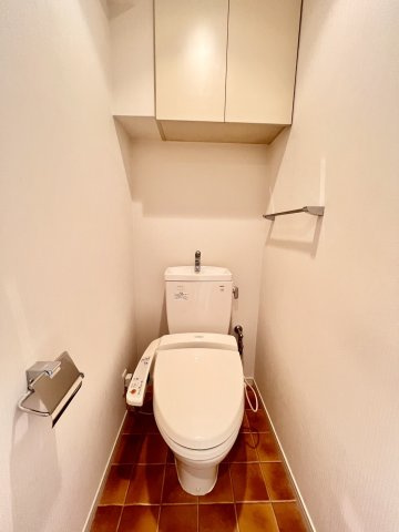 グランシアタワー狭山のトイレ|ウォシュレット付きの快適なトイレ。上部にトイレットペーパーや掃除用具を収納できる便利な棚付きです。