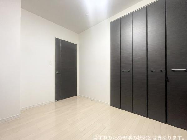 エイルマンション大分駅南イクシオの洋室|シンプルなデザインで落ち着いた雰囲気の洋室です。ダークカラーの建具が印象的です。クローゼットが備え付けられており収納面も安心です。ナチュラルなフローリングが空間を明るく見せています。