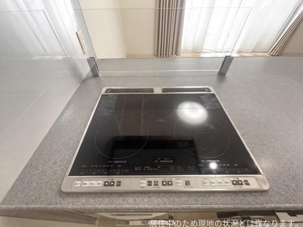 エイルマンション大分駅南イクシオのキッチン|シンプルで使いやすいIHクッキングヒーターが設置されています。フラットな天板なのでお手入れも簡単です。キッチン周りは広々とした印象で作業スペースも確保しやすい設計です。