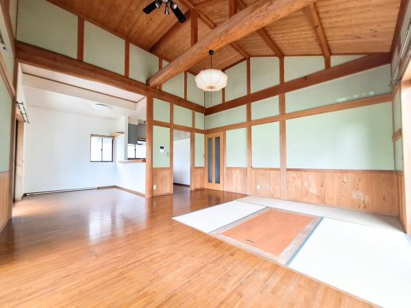 大字寒田　戸建ての居間・リビング|天井の梁が印象的なリビングです。畳スペースとフローリングが調和した空間となっています。木の温もりを感じられるデザインが特徴です。窓からの採光で明るさが保たれています。