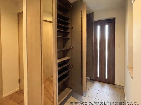 京が丘南4丁目　中古の玄関|収納スペースが充実した玄関は整理整頓しやすく機能的です。明るい木目調のデザインが空間に温かみを与えています。シューズボックスの扉が鏡になっており外出前の身だしなみチェックにも便利です。